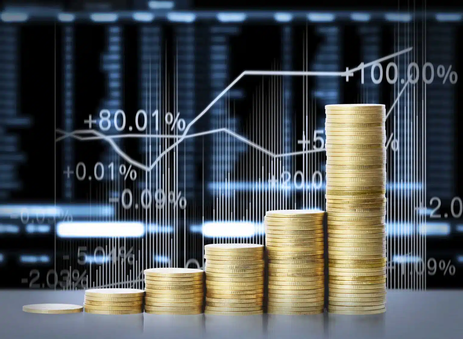 La finanza al centro dell'attenzione: monete su un tavolo con grafico di borsa in background.